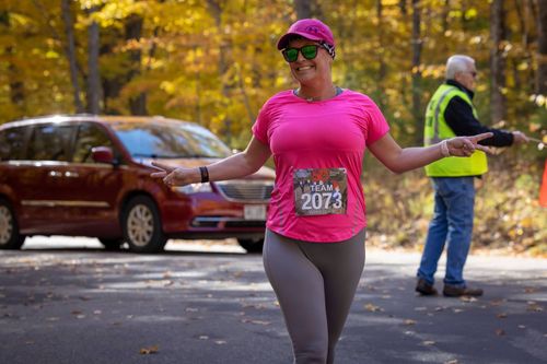 A female runner posing for a picture while runner in Peninsula State Park during the fall colors