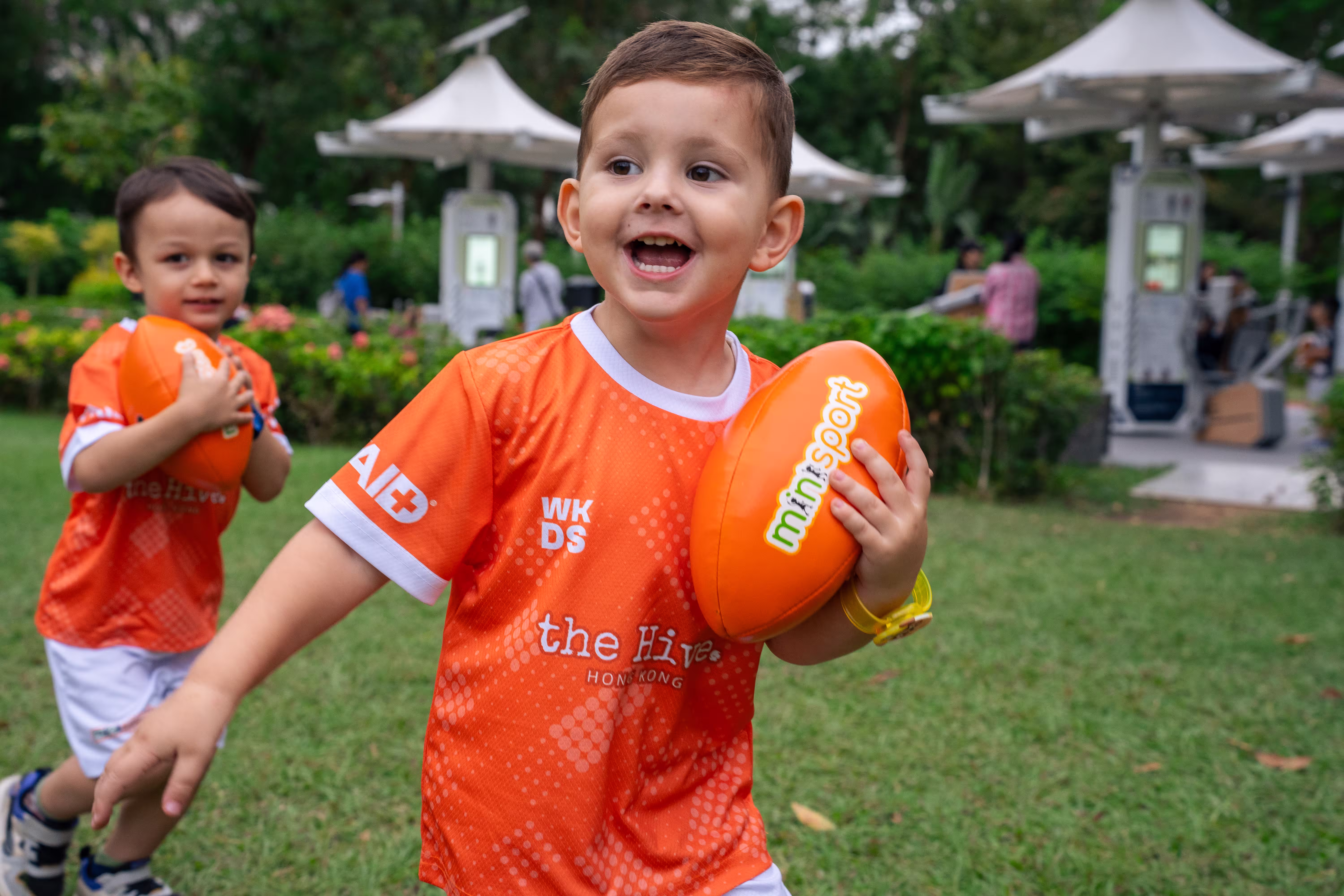A kid in minisport uniform holding a football