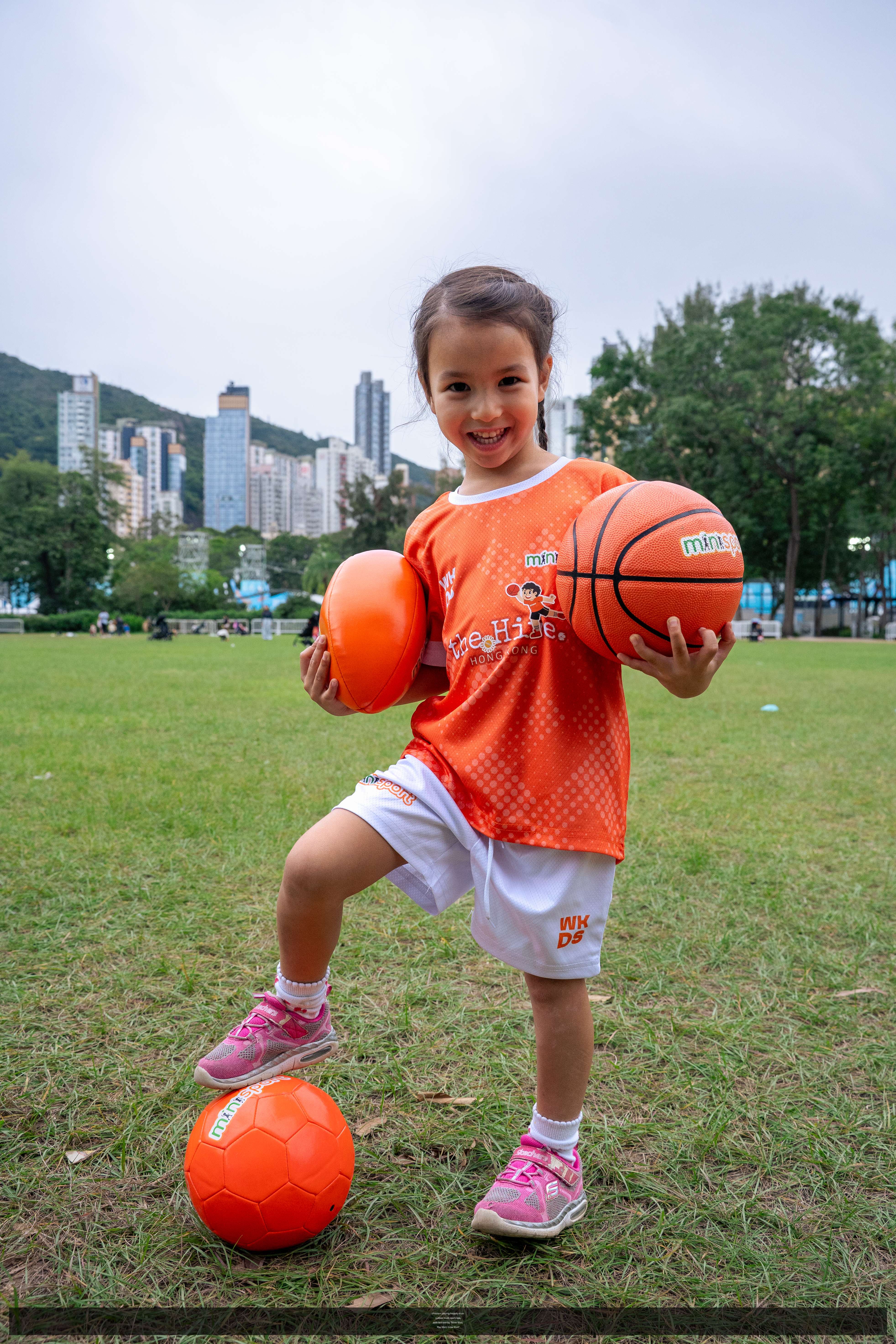 children playing happily in an outdoor multi-sport class, with text overlay