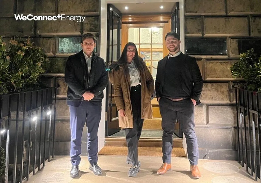 three people posing in front of a building