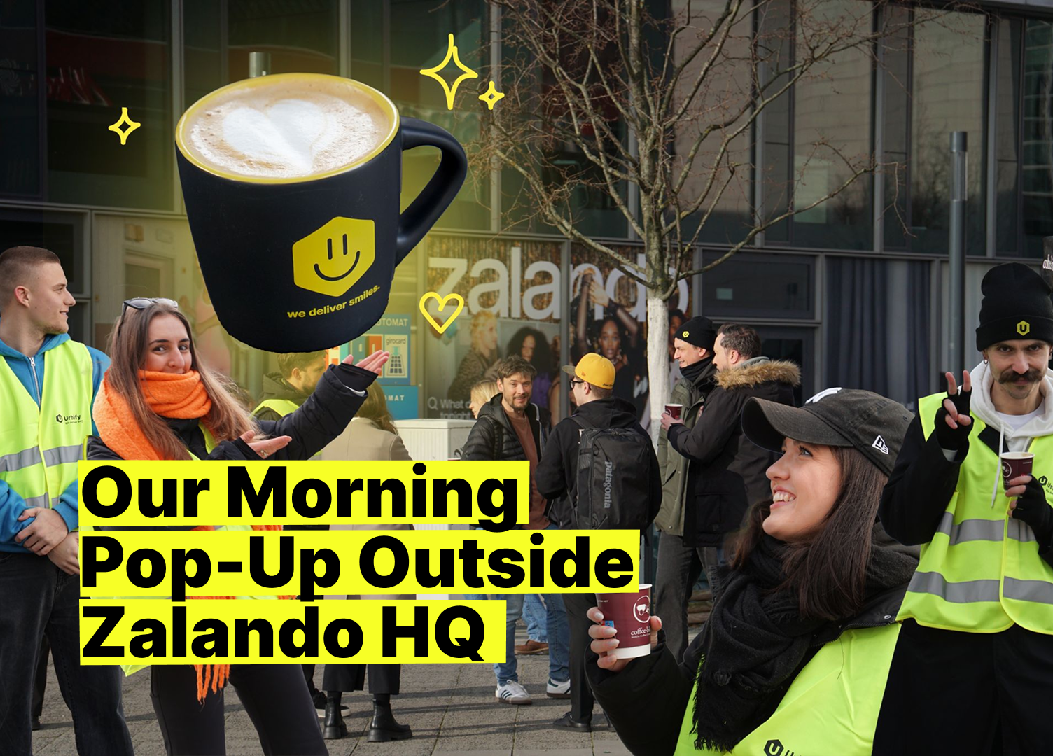A cheerful group of Urbify employees, some in Urbify vests, enjoy coffee together at a morning pop-up event outside Zalando HQ. A large coffee cup graphic with a smiley face and the phrase “we deliver smiles” highlights the friendly, welcoming atmosphere.