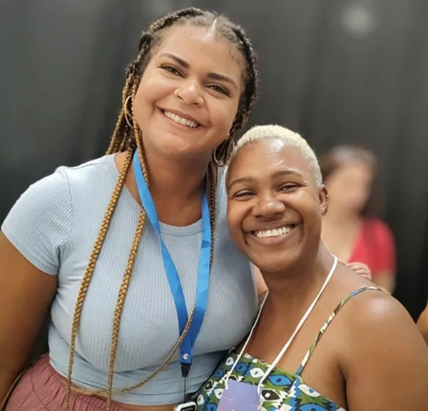 Two young black women smiling at the camera