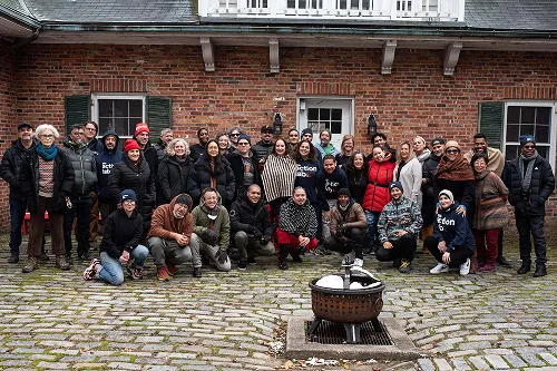 A group of people posing in The Action Lab's outdoor courtyard in Ossining New York