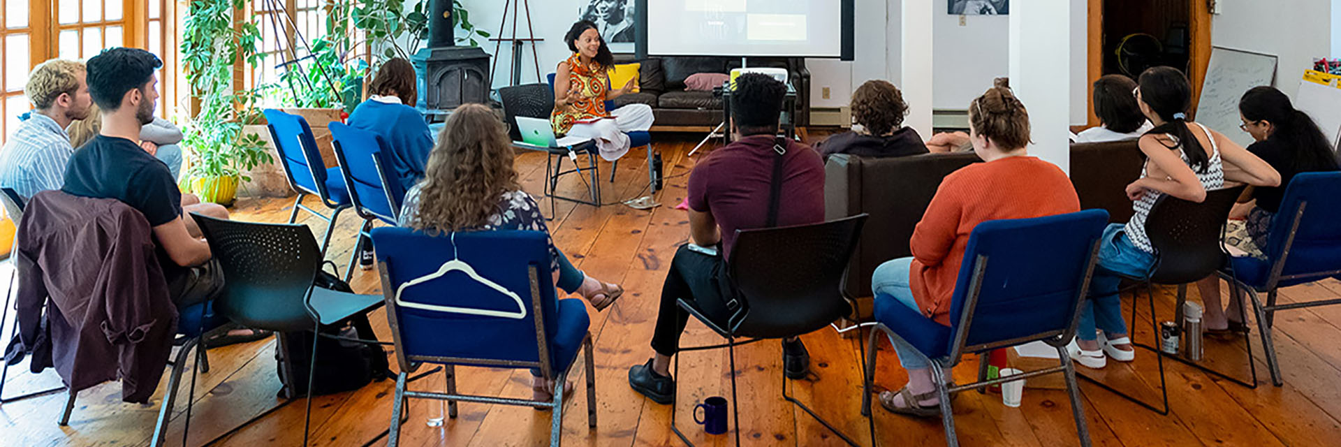 A woman giving a presentation to a room full of seated students