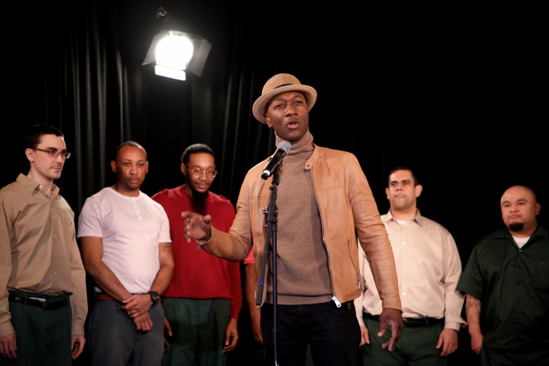 Aloe Blacc performing at Sing Sing Prison, accompanied by a group of inmates, during the 'Beyond the Block' event.