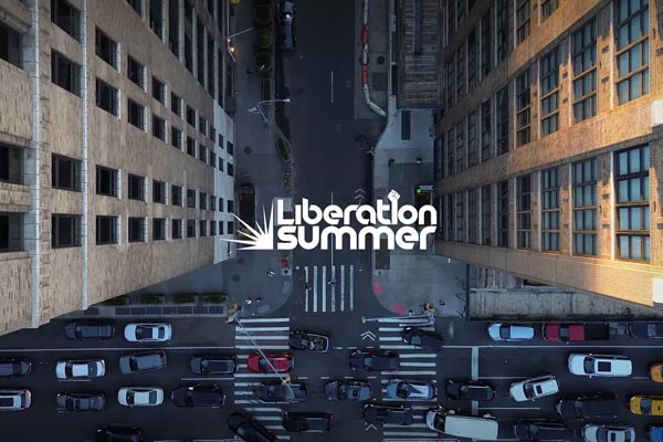 Aerial view of a busy city street between tall buildings with the Liberation Summer logo