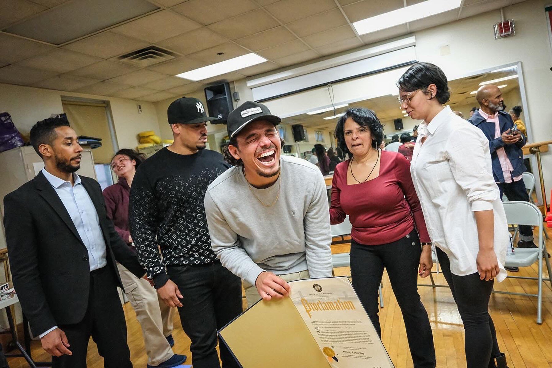 Anthony Ramos laughing with his family after receiving an honor at Bushwick Campus.