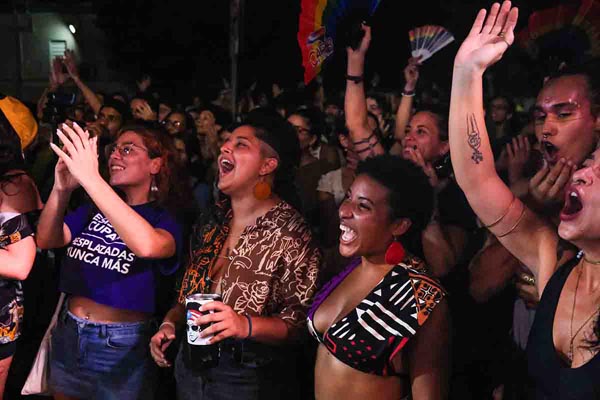Cheering crowd celebrates at a lively nighttime event.
