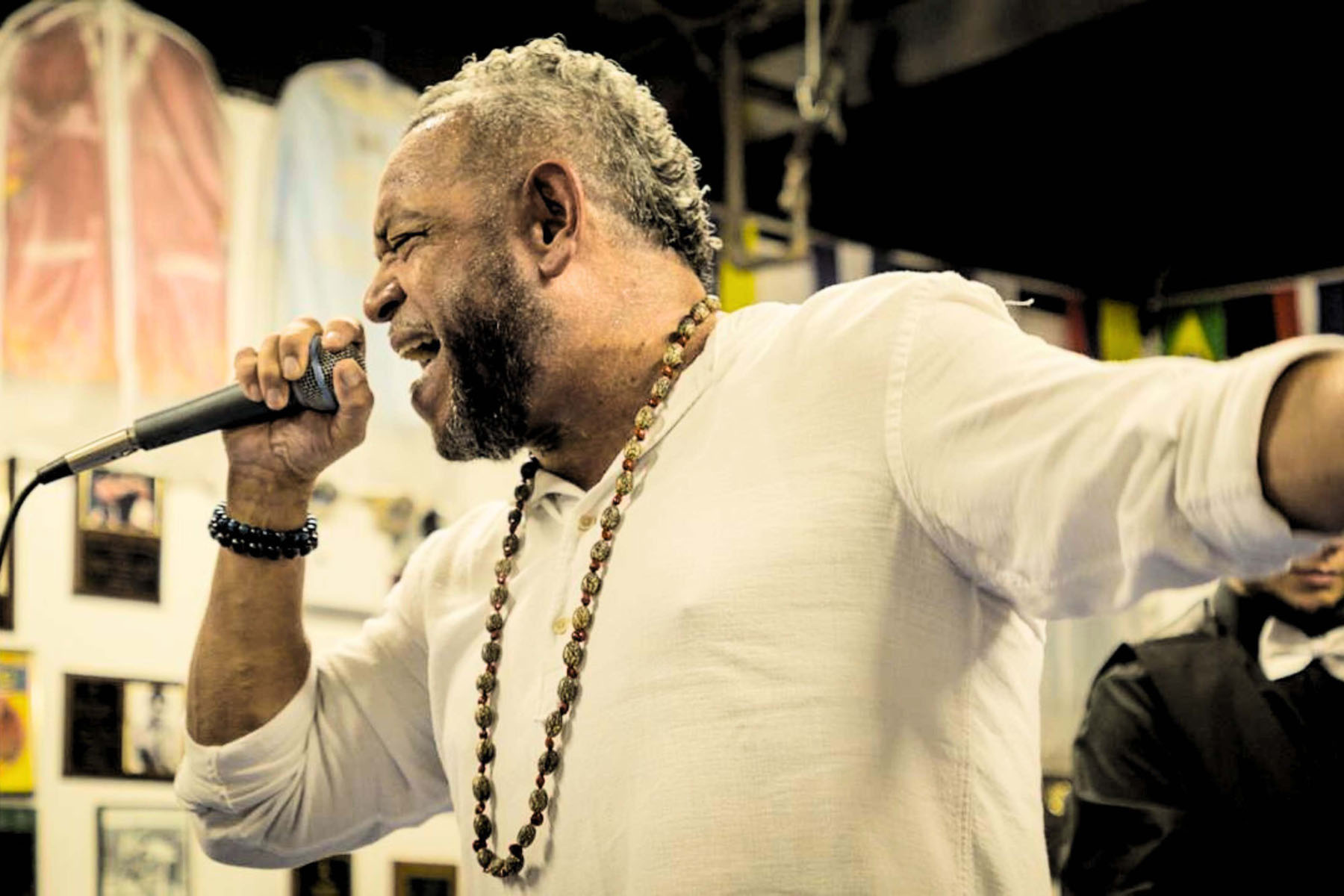 Singer performs passionately into a microphone in a decorated indoor space.