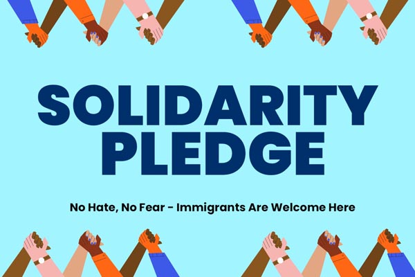 Graphic with raised hands and bold text reading “Solidarity Pledge — No Hate, No Fear.”