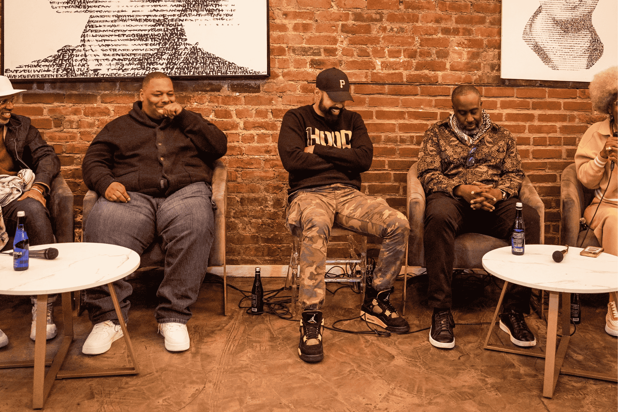 Four people seated in a semi circle conversing on a panel.