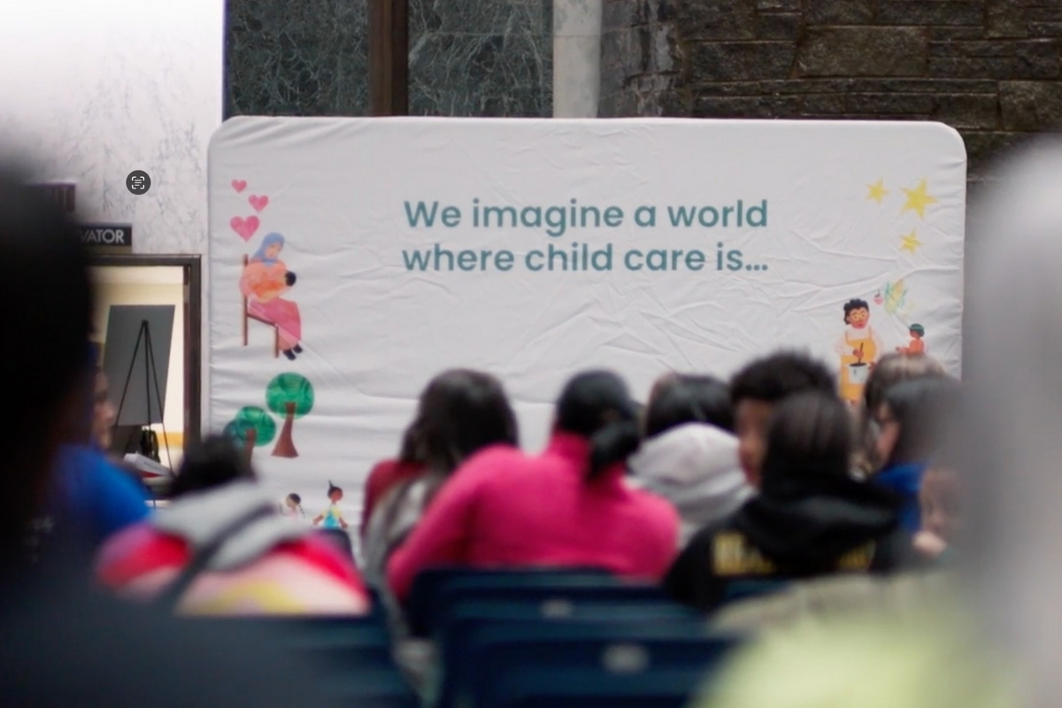 Audience seated in front of a display about child care.