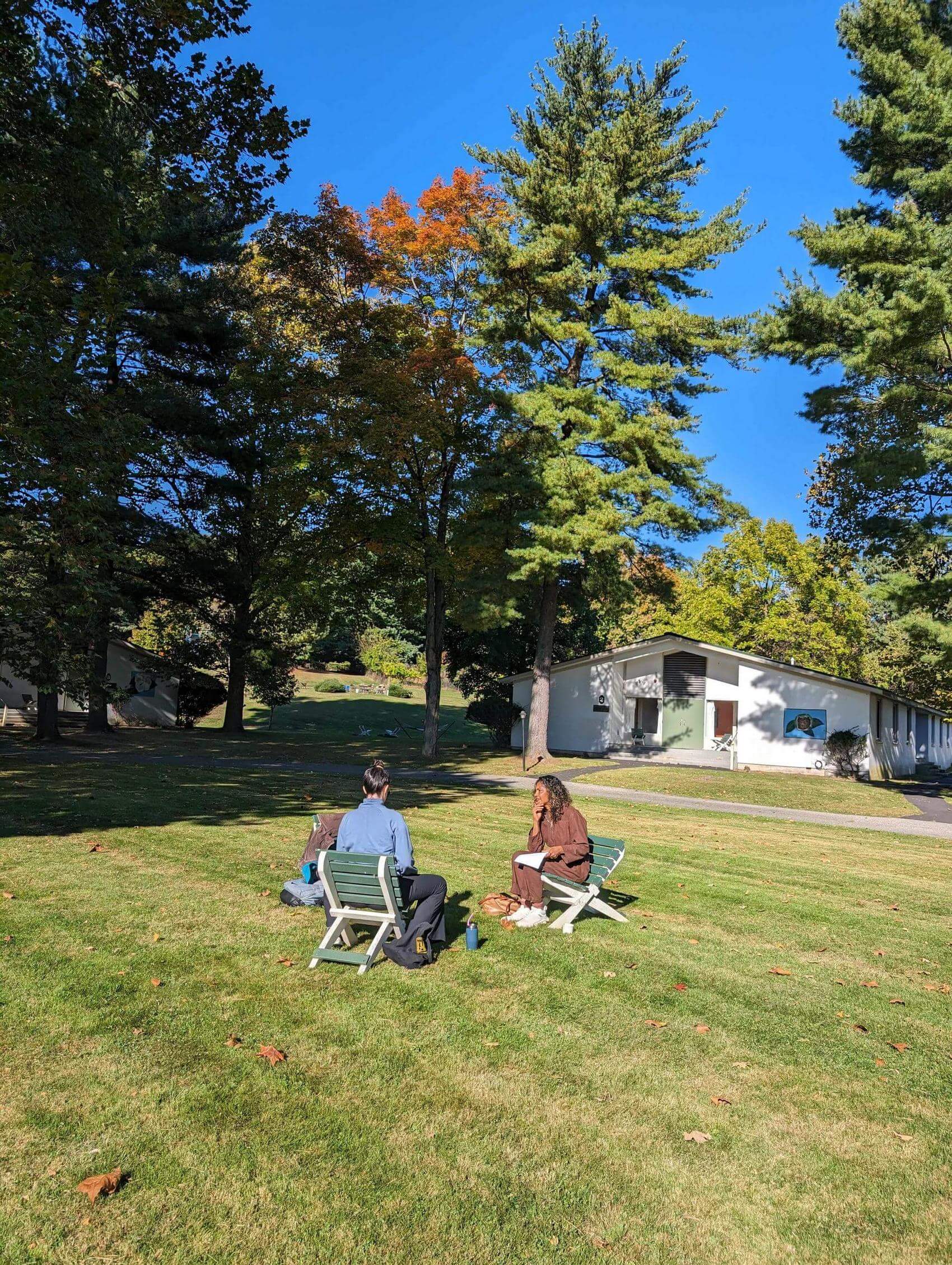Group discussion with participants seated in a circle and a speaker at a table.