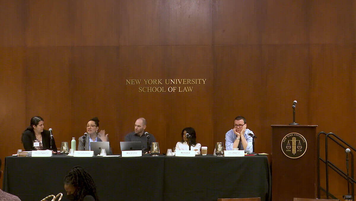 Panel discussion at New York University School of Law with five speakers seated at a table.