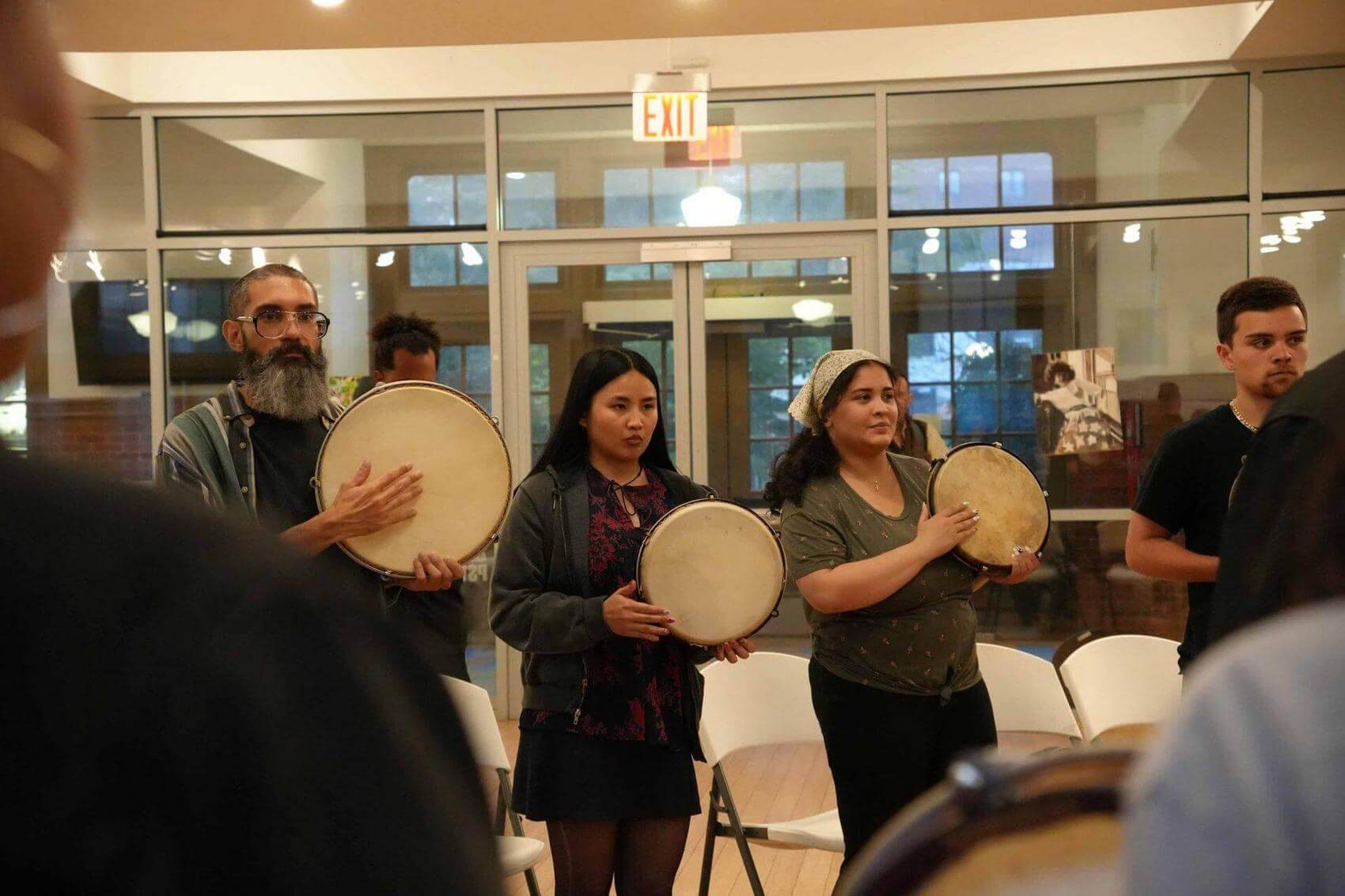 Group of people holding hand drums.