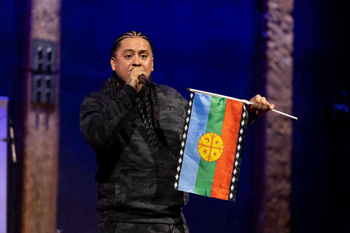 Four speakers on stage at an event.