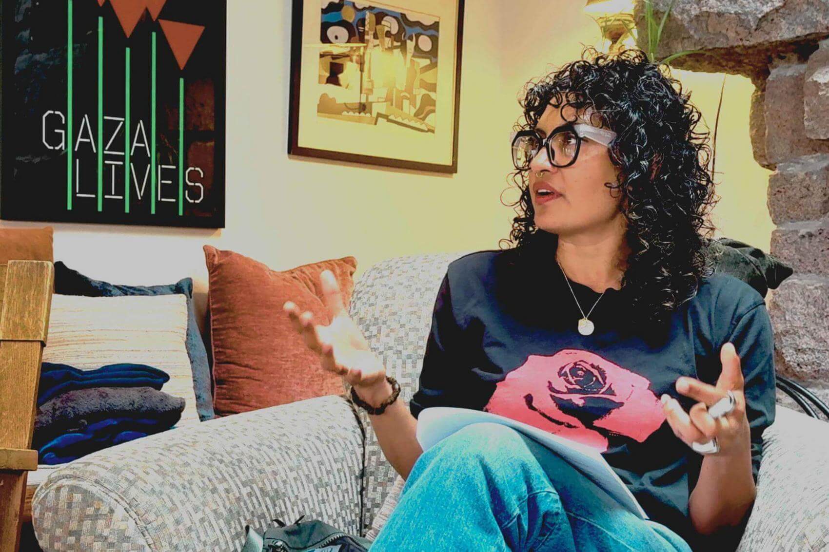 Woman with wearing glasses, sitting on a couch.