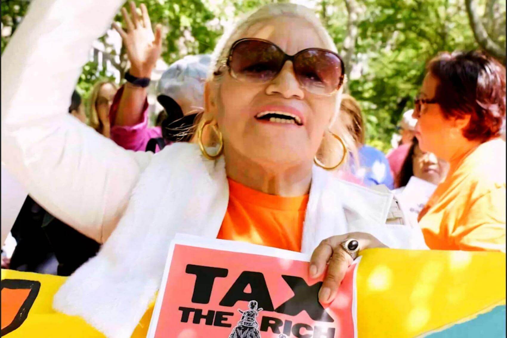Five women hold protest signs conveying messages about childcare and caregiving.