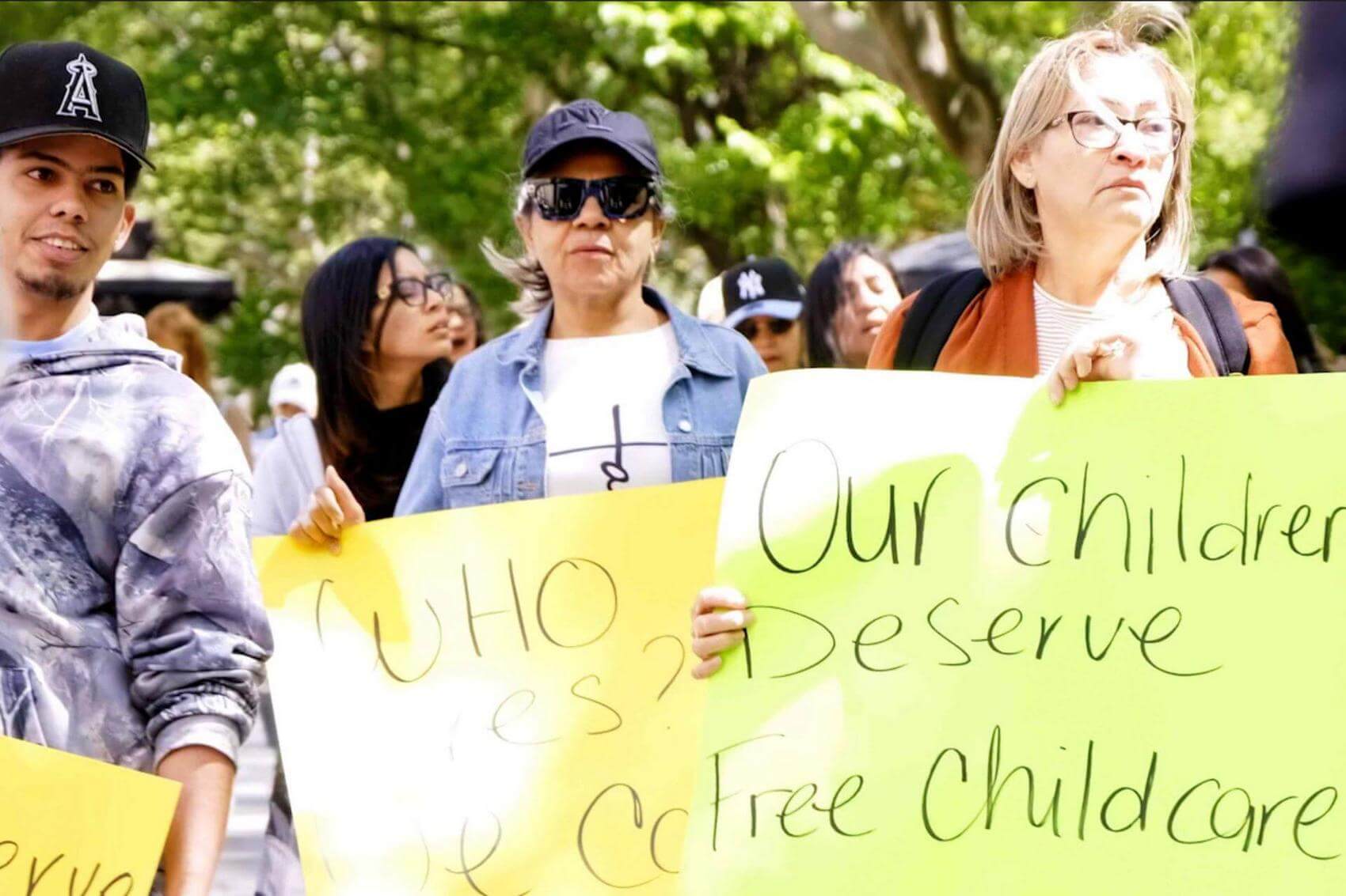 Older woman holding a sign that reads "TAX THE RICH