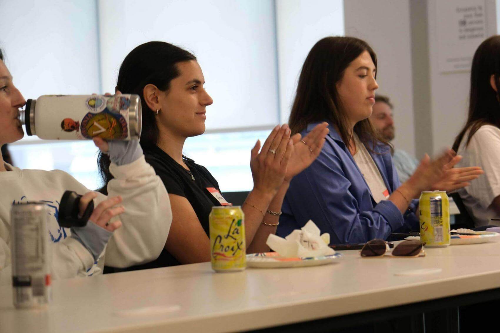 Speaker at a podium addressing an audience, showing a presentation with logos for Make The Road New York.