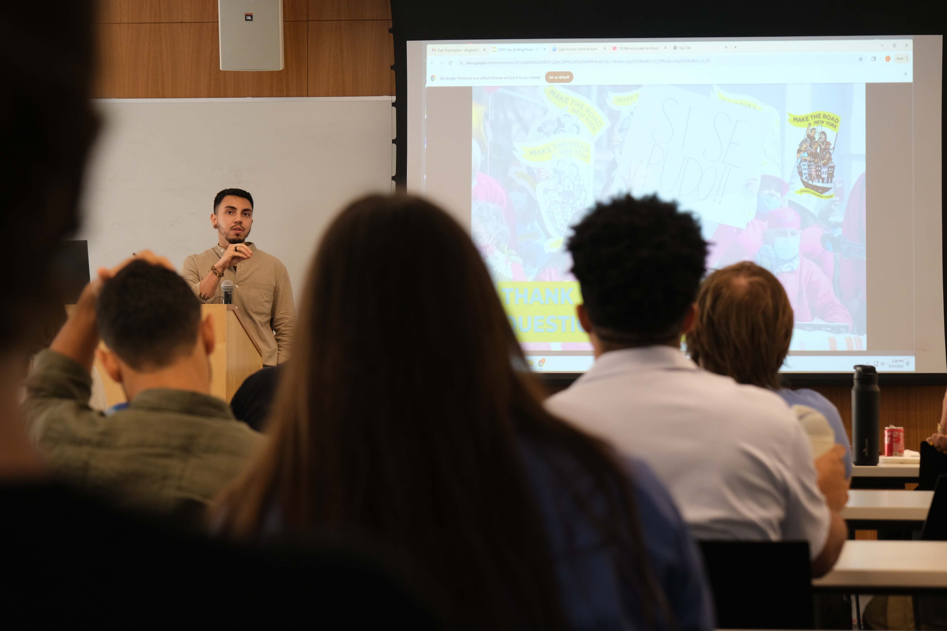 A group of young people sitting at tables smiling and listening attentively.