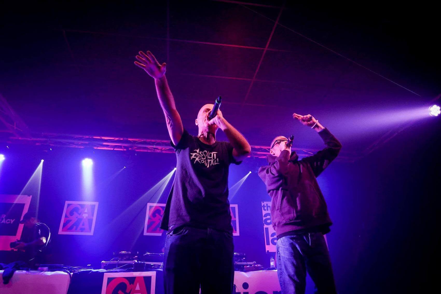 Four people engaged in conversation, with one person pointing and another looking at a phone.