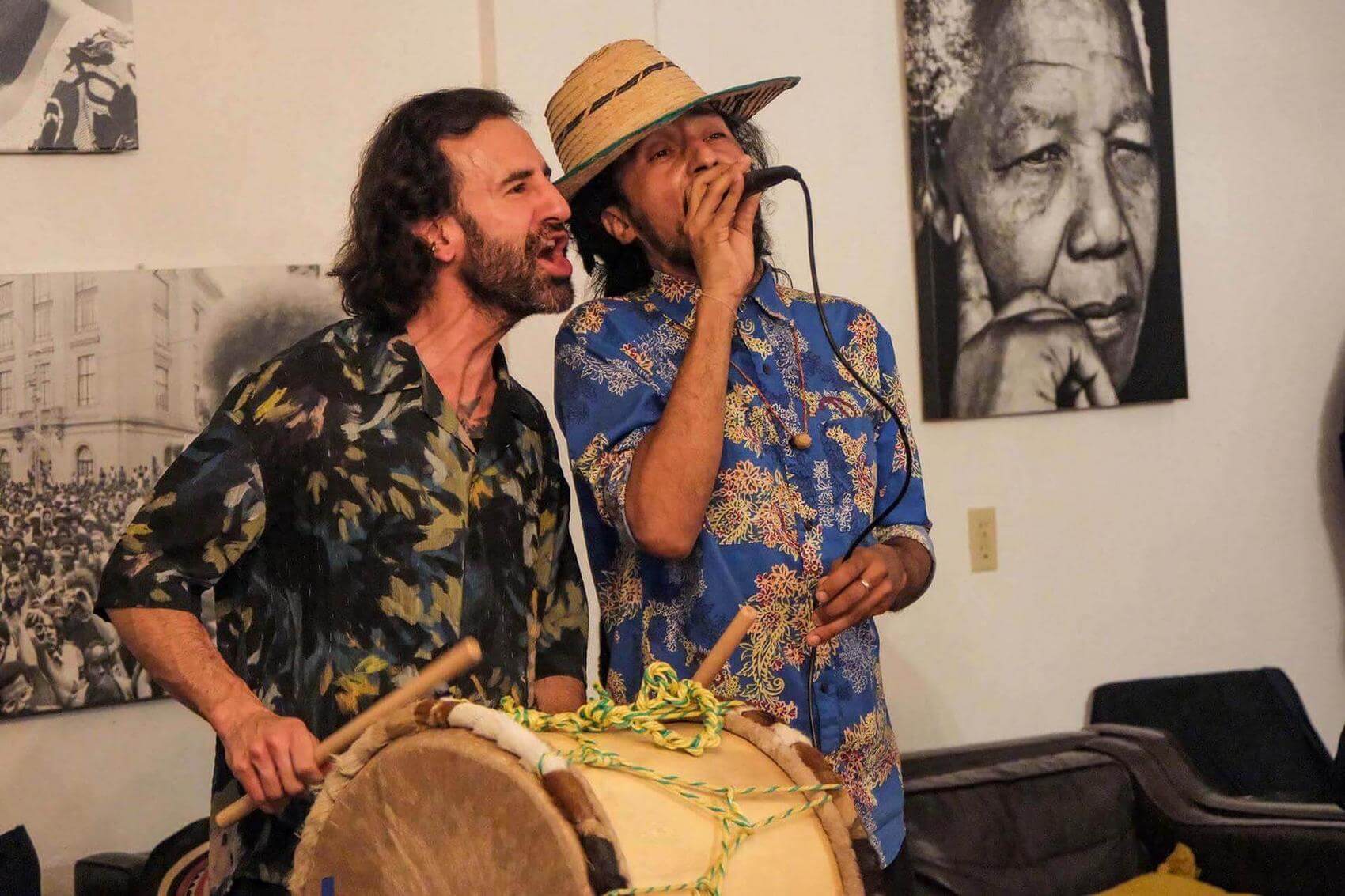 Person presenting information to a seated group in a meeting room with charts and signs displayed.