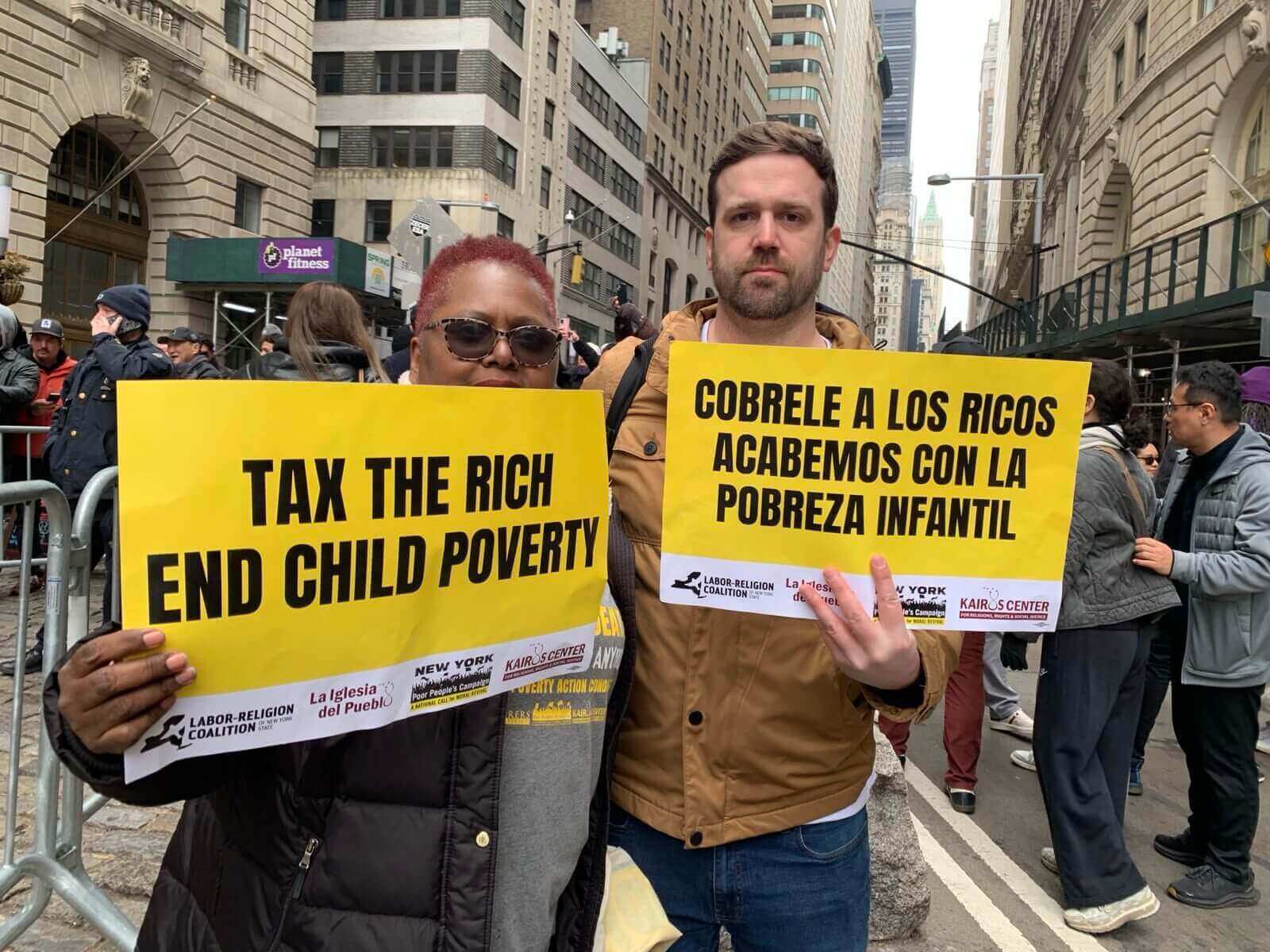 Crowd at a protest holding a large banner reading "REJECT FASCISM."
