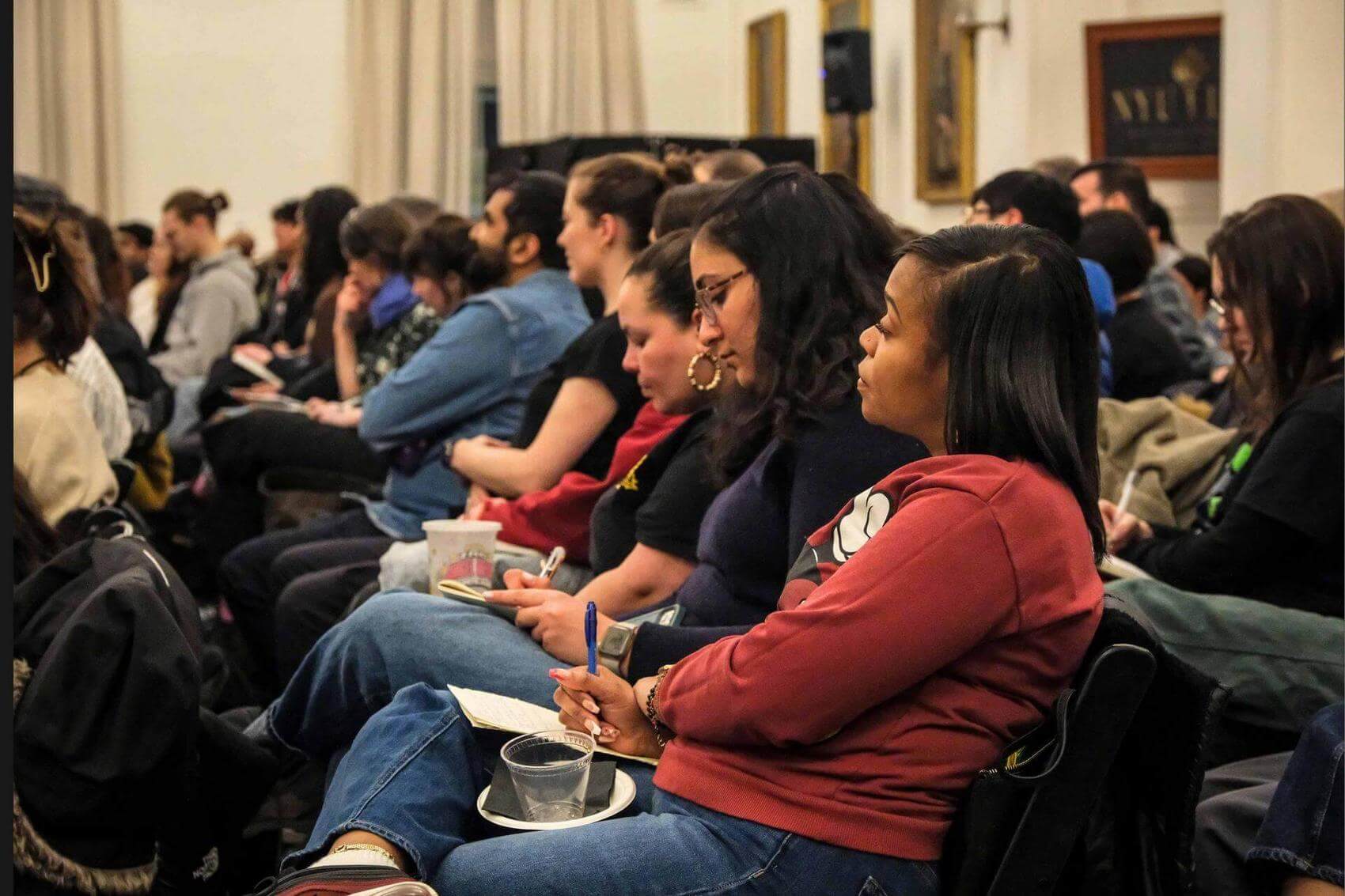 Discussion event with two speakers seated in armchairs, audience facing them.