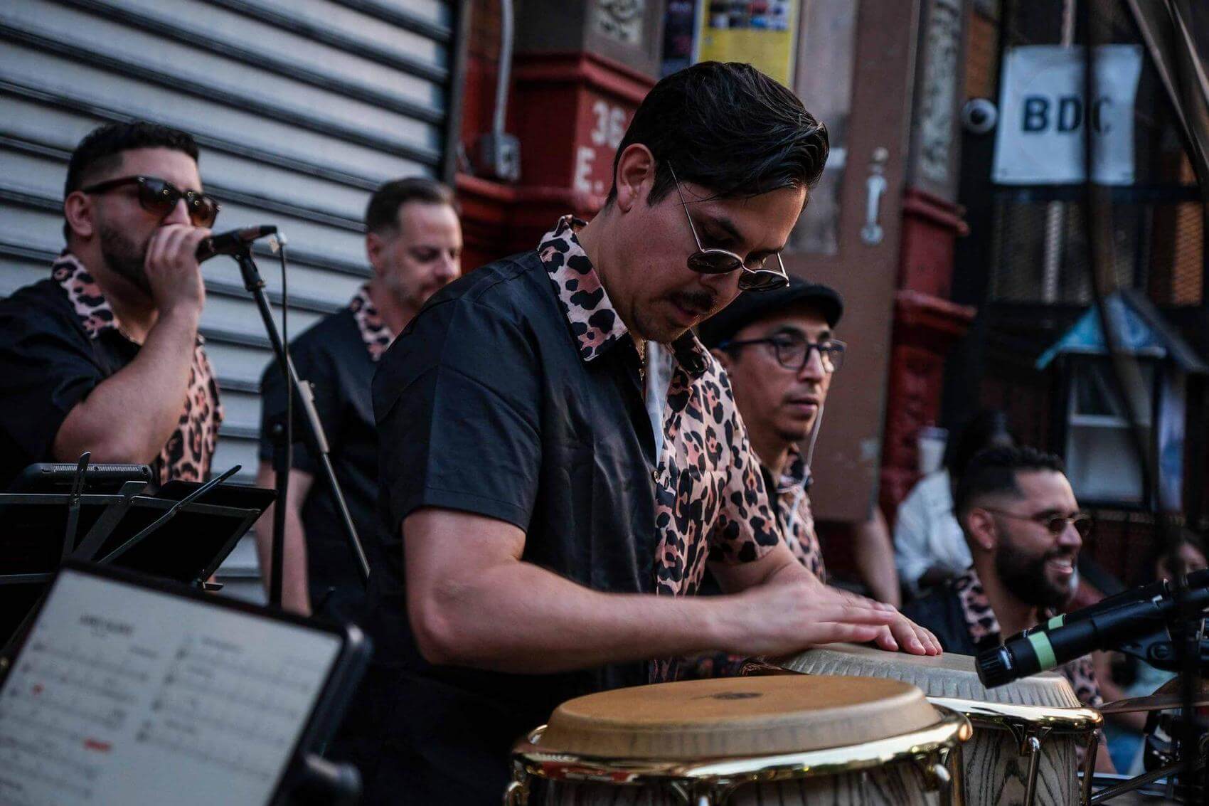 Crowd of people enjoying an outdoor event, some smiling and talking in the evening.