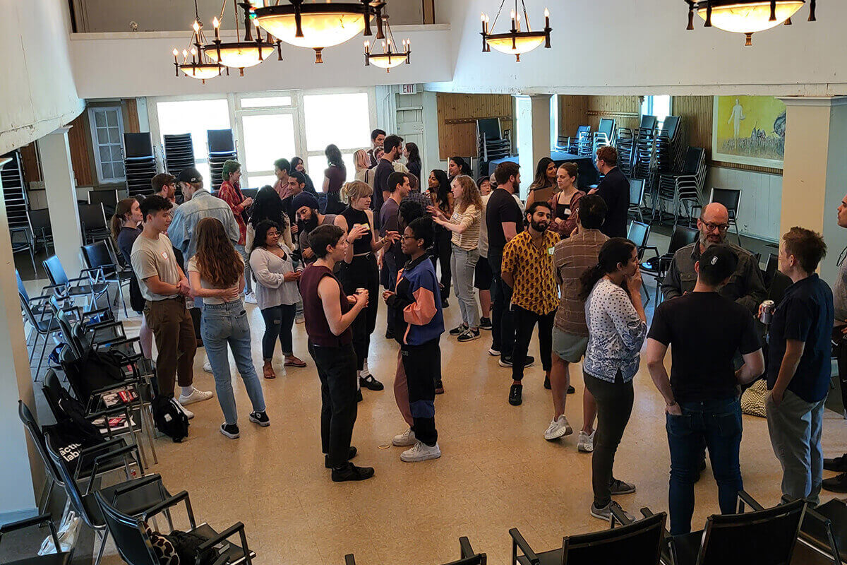 Group of people sitting on a stone wall with a scenic view.