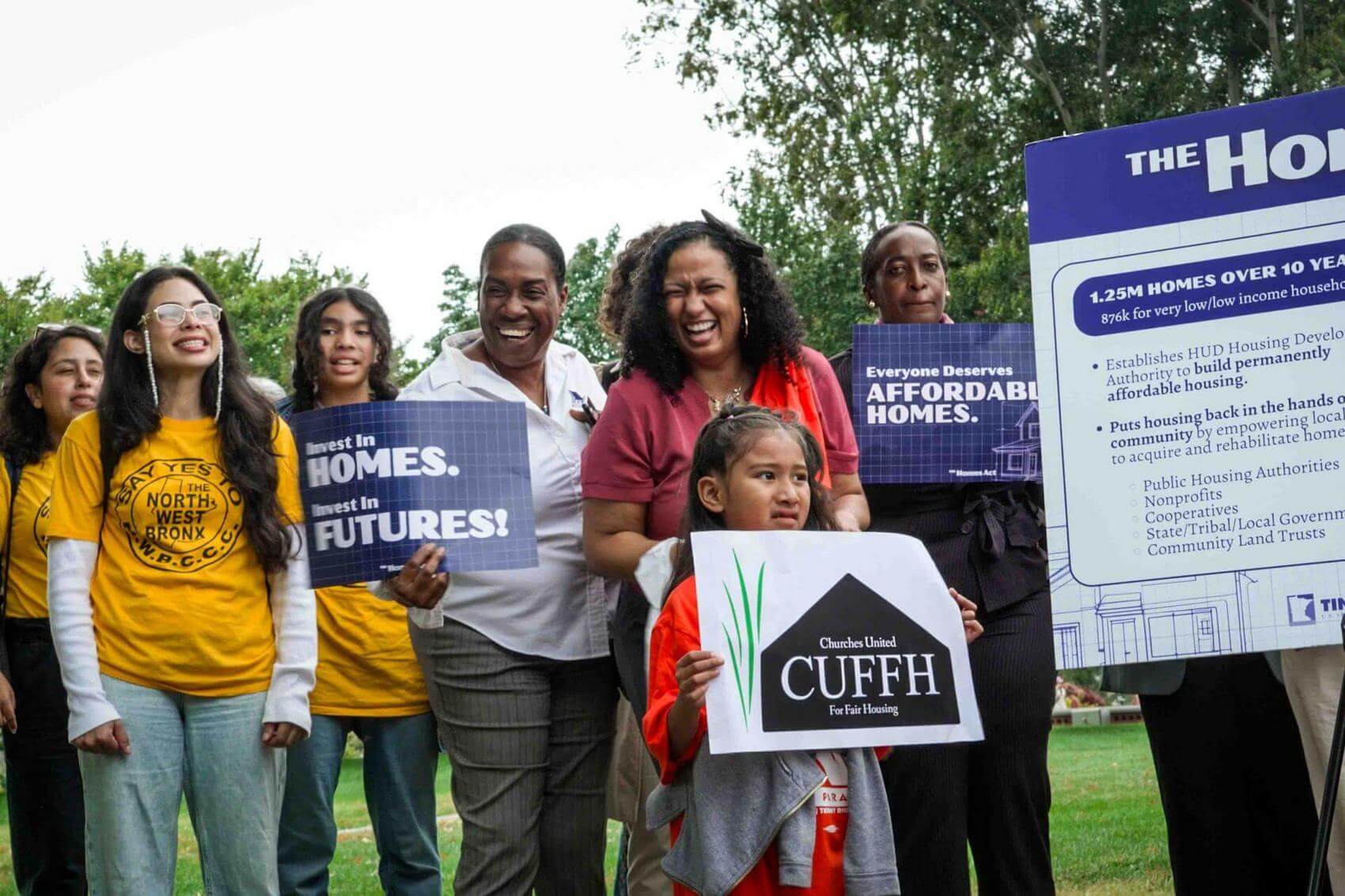 Woman speaking at a podium with "The Homes Act" sign