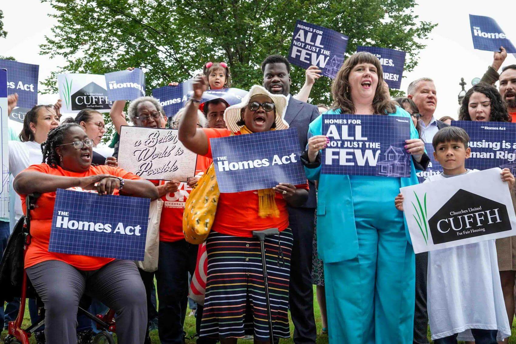 A person raises a fist while speaking passionately at a table with others present.