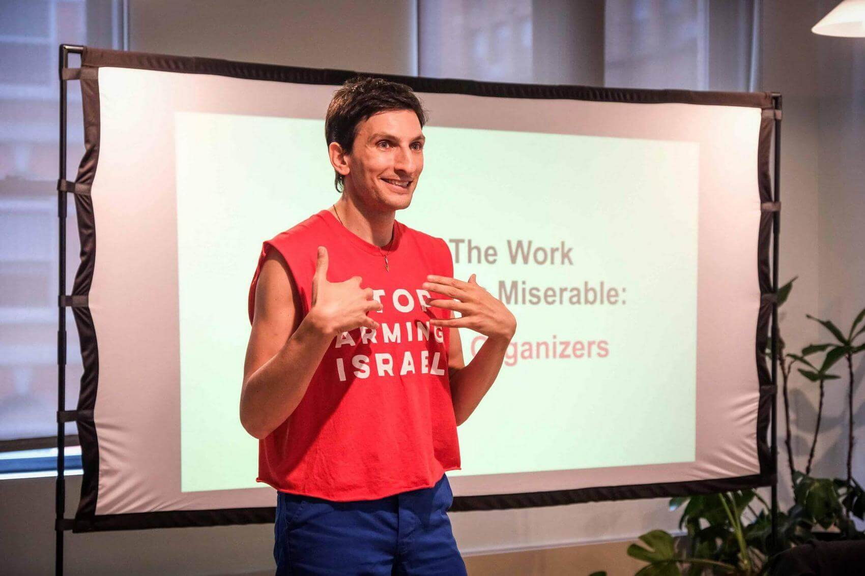A woman smiling among a group of people sitting, smiling, and laughing.