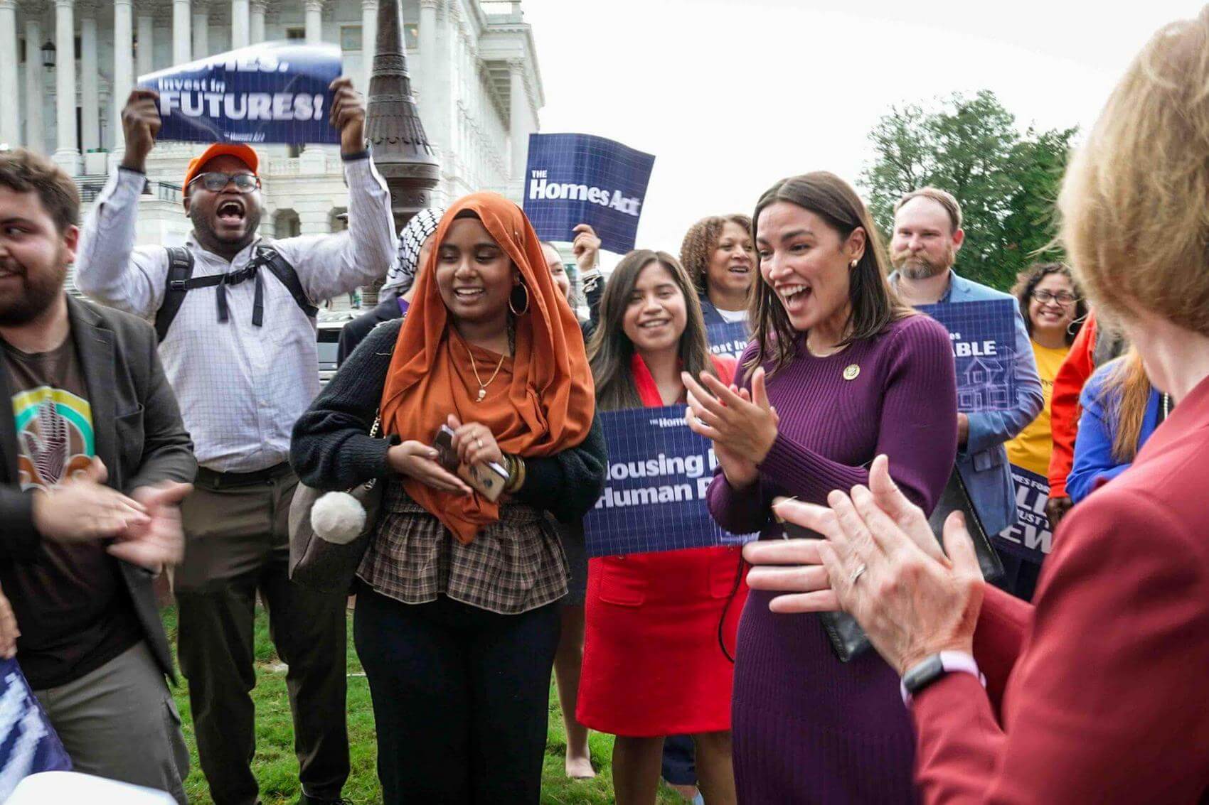 Capitol building in background, crowd applauding.