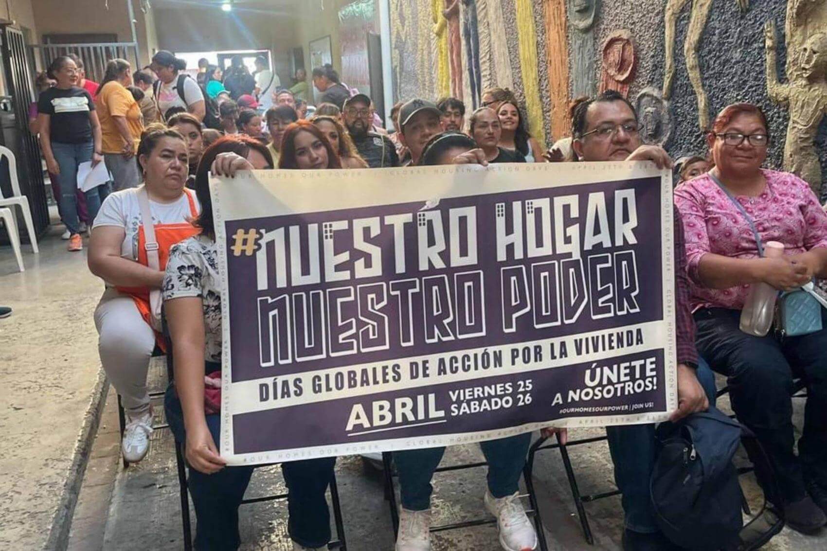 Group of people holding signs and a banner, advocating for housing rights and social justice.