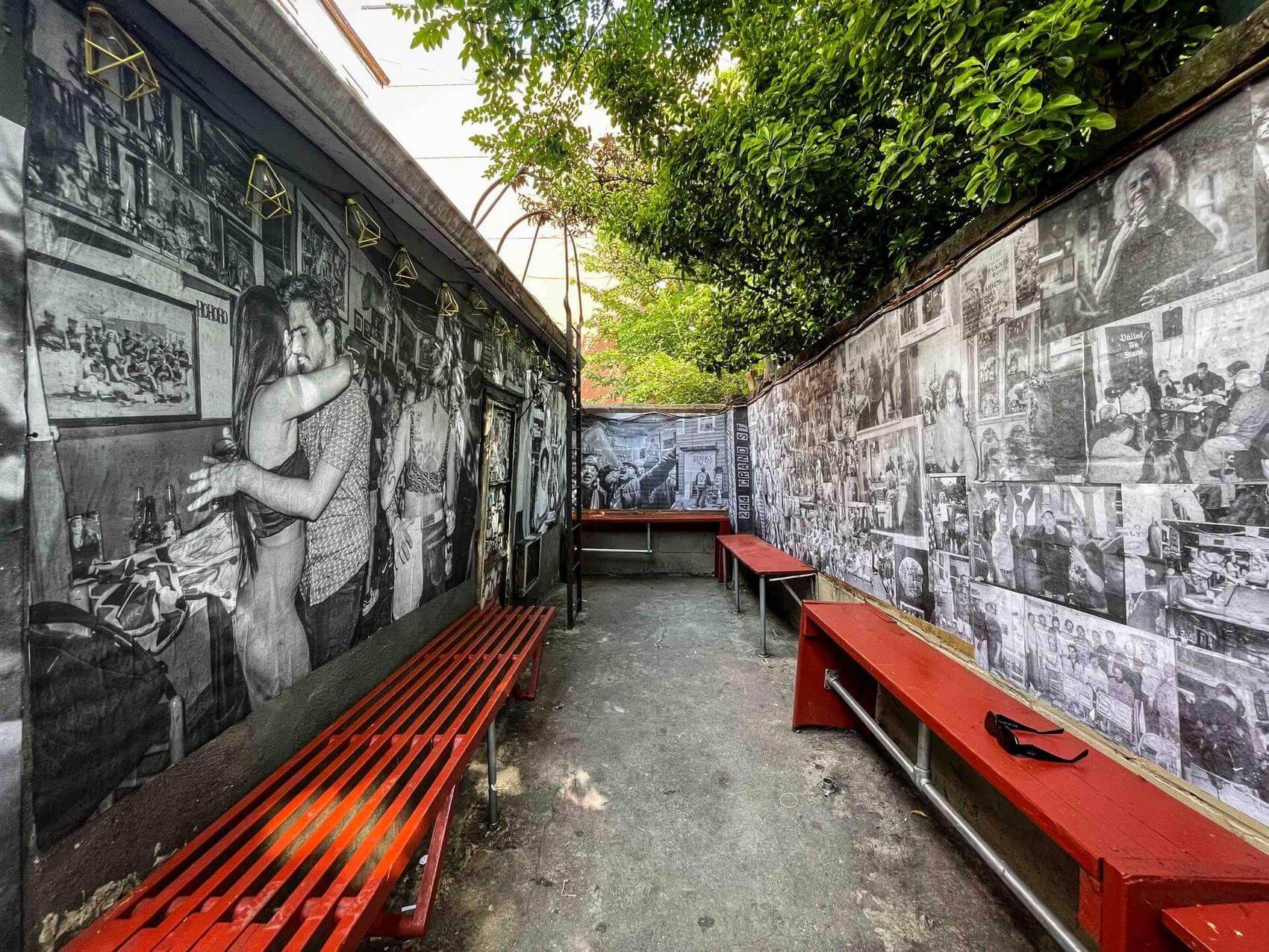 A narrow outdoor space with walls covered in black and white photos.
