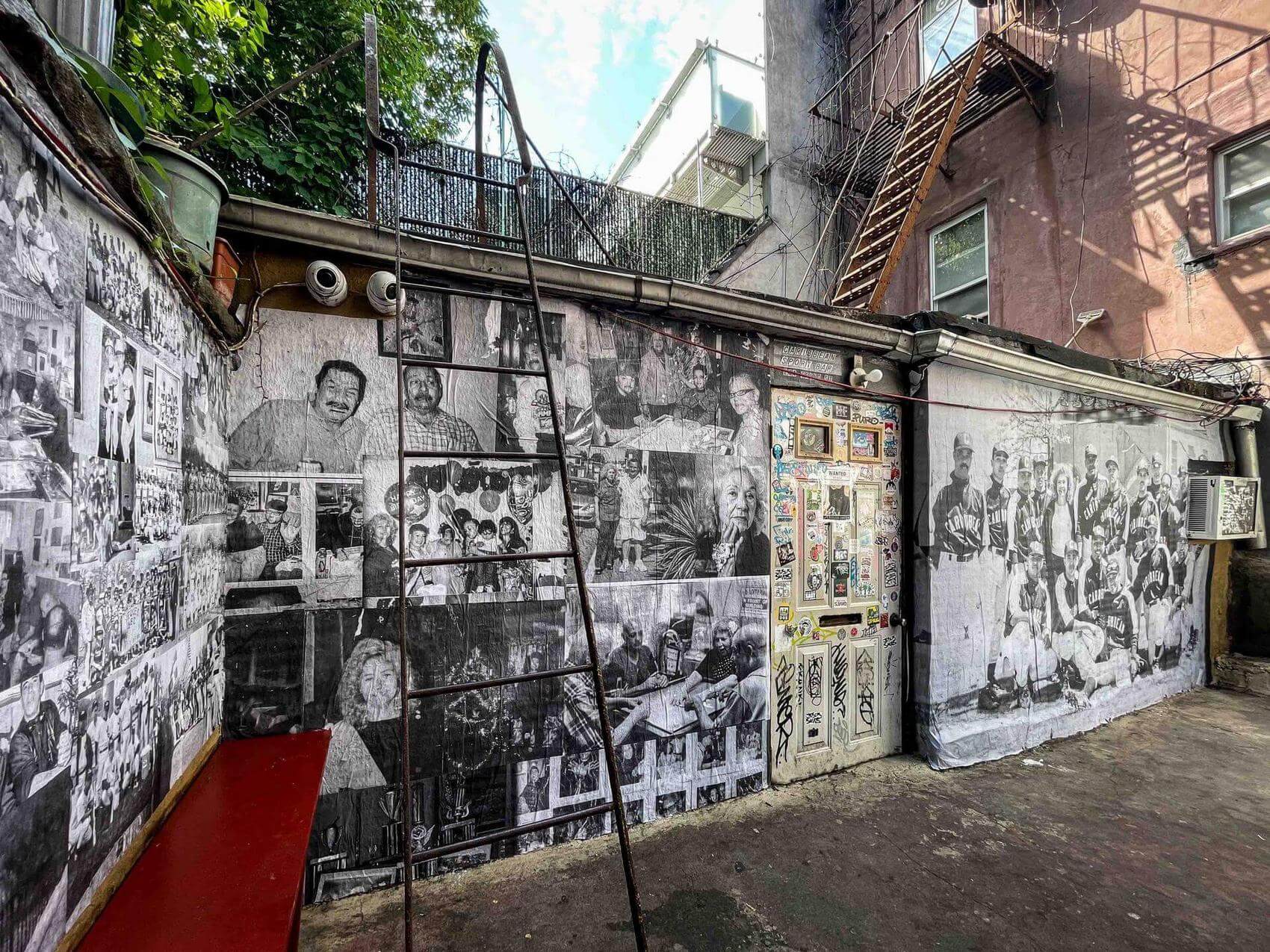 Collage of black-and-white photographs showing various people and scenes on a wall.