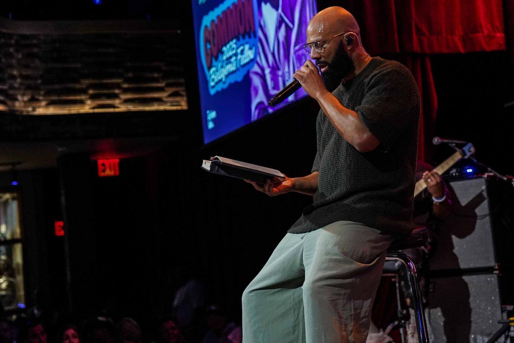Common rapping into a microphone on stage