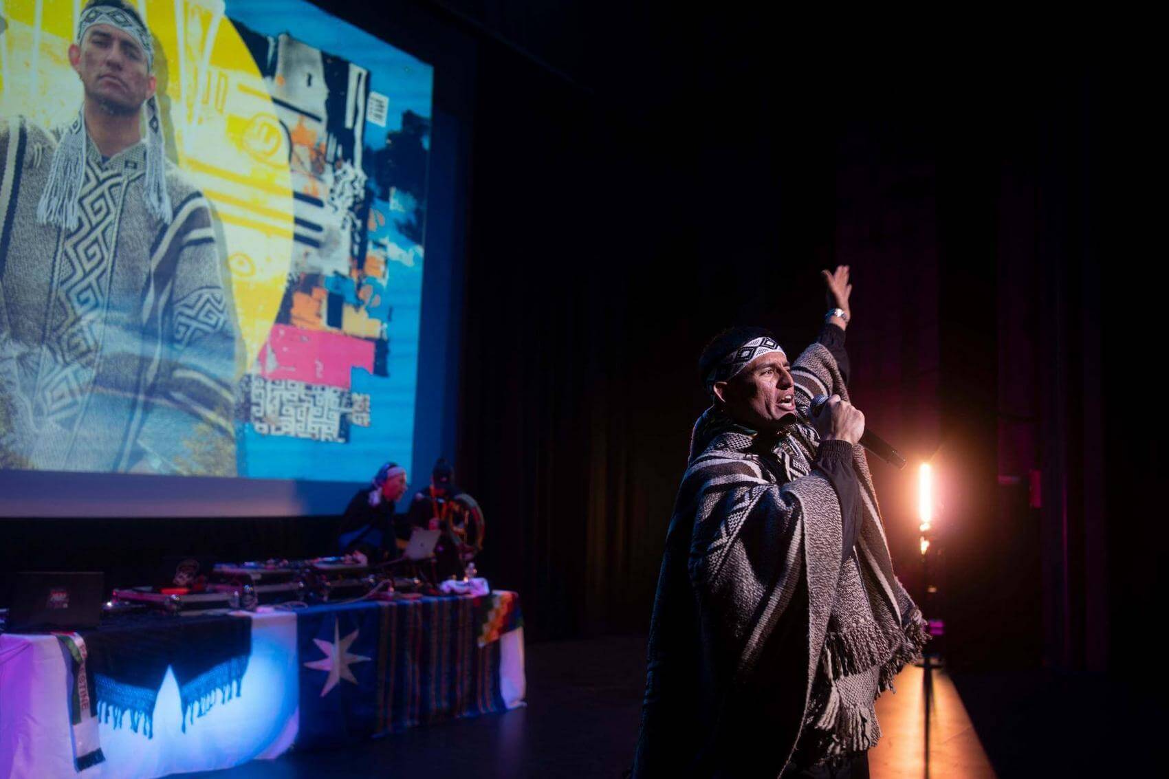 Two dancers perform on stage, one executing a handstand while the other crouches nearby.