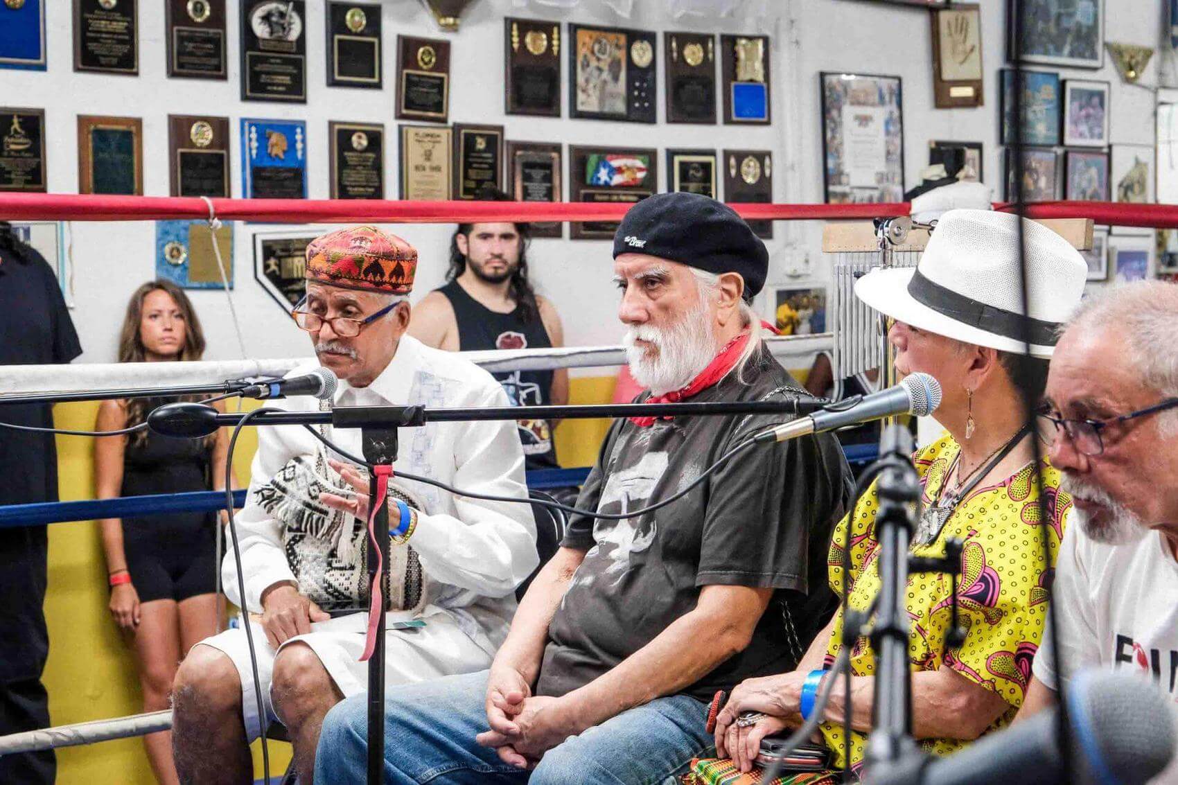 Two women dance and interact joyfully in a crowded indoor space