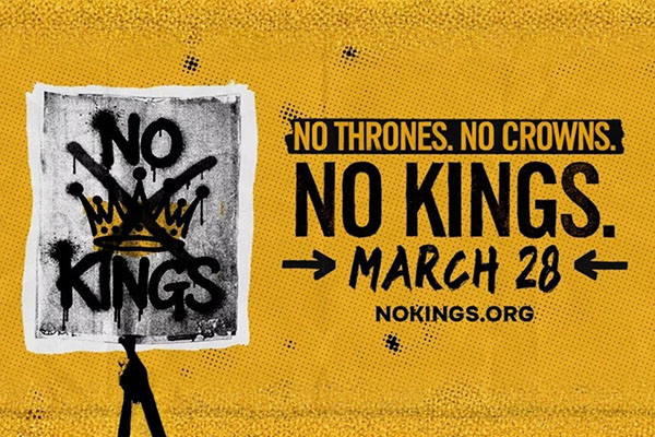 Community members marching in protest with signs calling for democracy and people power.