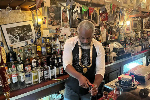 Owner working behind the bar at Jimmy’s Corner, a historic Midtown dive bar facing eviction in New York City.