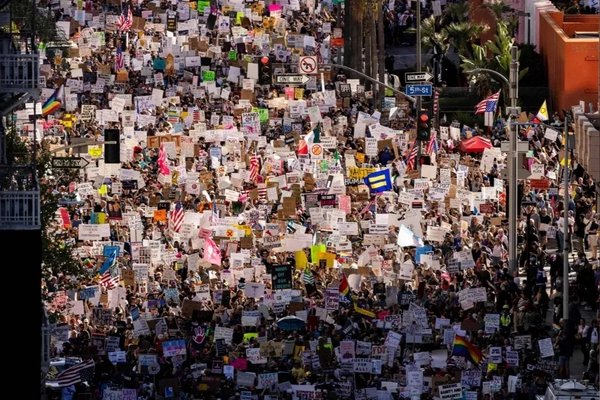 Large crowd of protesters marching with signs in New York City, representing community mobilization to defend Jimmy’s Corner and small businesses.