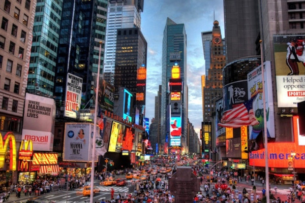 Times Square in New York City with crowds, traffic, and illuminated billboards, representing the urban landscape where small businesses face rising rent pressures.