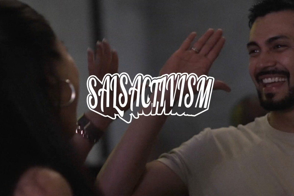 Event image for “Salsactivism” showing two people high-fiving at a community gathering with stylized title text overlay.