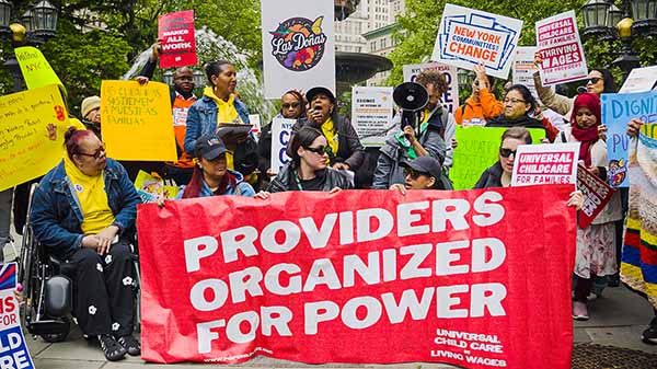 Group photo of organizers smiling on stairs with text overlaid: “Providers Organized for Power and New Mayoral Commission.”