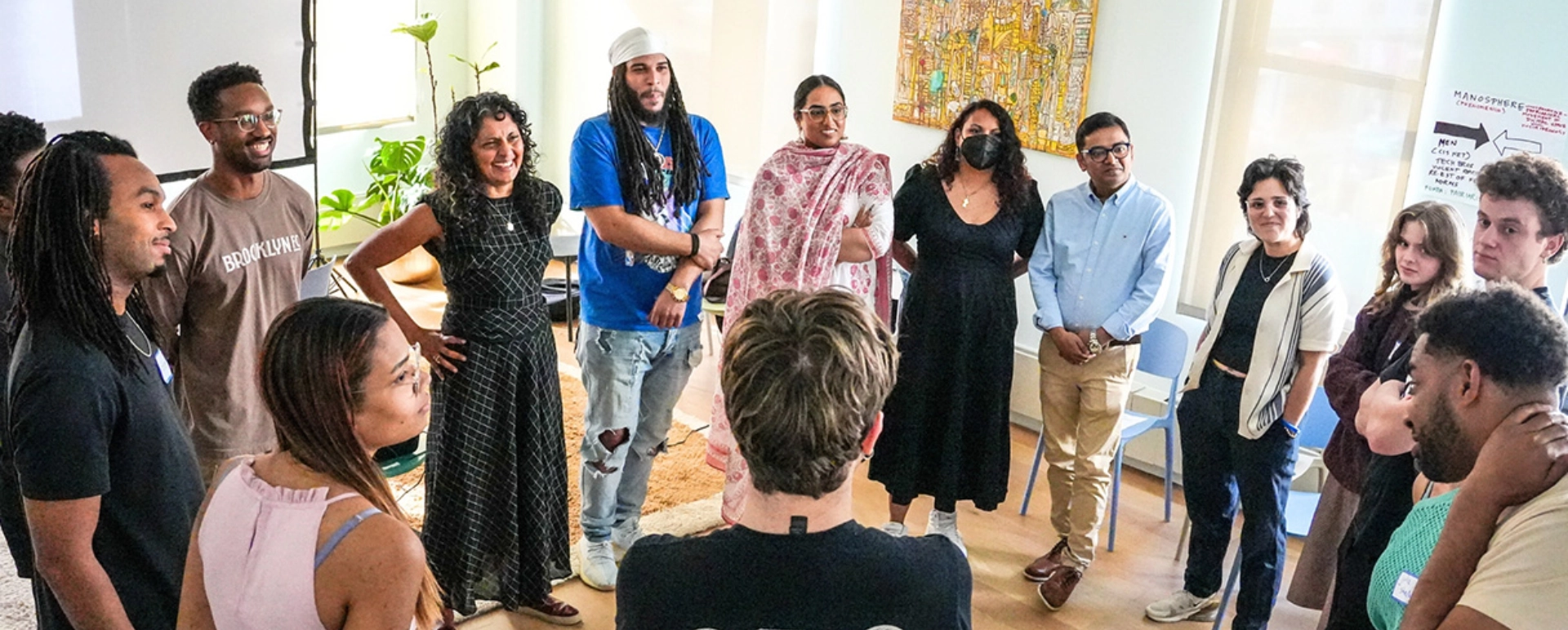Diverse group of people standing in a circle during a community gathering.