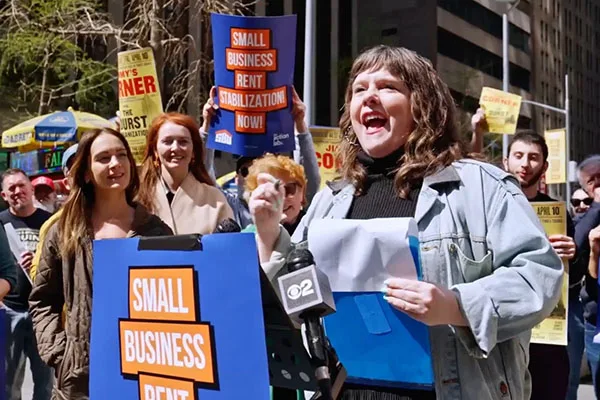 Woman speaking at a rally supporting small business rent stabilization.