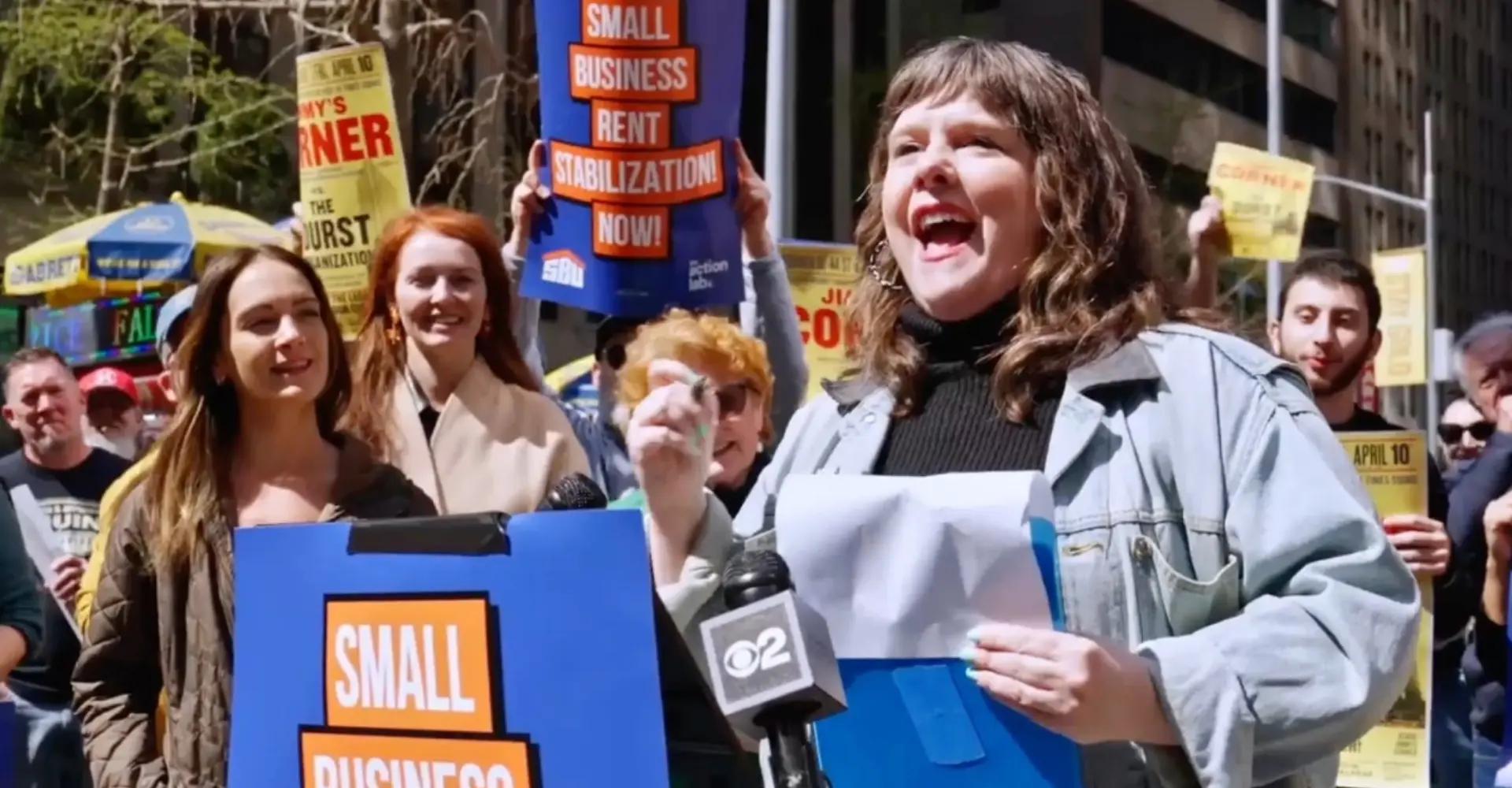 Woman speaking at a rally supporting small business rent stabilization.